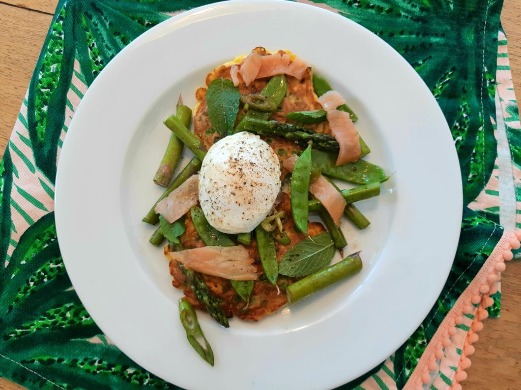 Springtime Pea and Feta Fritters served here with a fresh salad, smoked salmon and poached egg for a balanced and delicious meal.