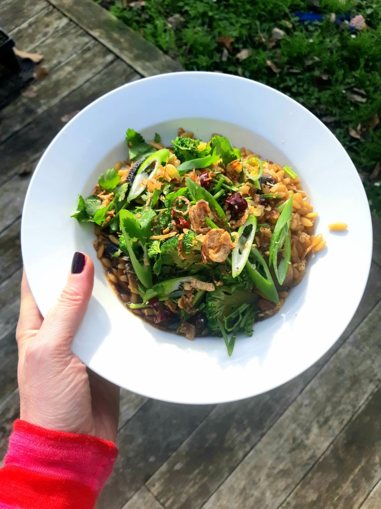 A hand holding a bowl with the Super Easy Green Bowl recipe